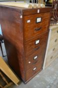 An old wooden four drawer filing cabinet.