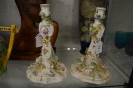 A pair of Continental porcelain floral encrusted candlesticks (faults).