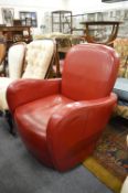 A red leather cloth upholstered Art Deco style armchair.