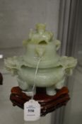 A Chinese carved jade koro and cover on hardwood stand.
