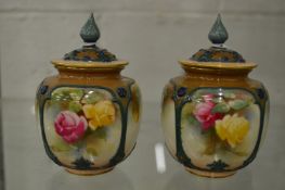 A pair of small Worcester floral decorated potpourri vases and covers (one cover damaged).