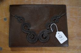 A Yves Saint Laurent brown leather clutch bag.