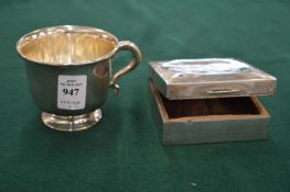 A silver cup and a cigarette box.