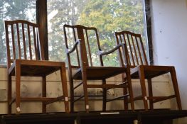 A pair of oak and rush seated dining chairs and a carver chair.