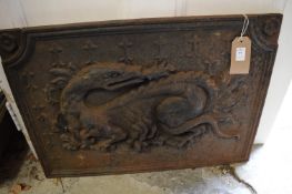 A cast iron fire back depicting a dragon.