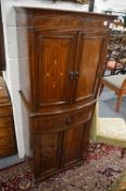 An Edwardian inlaid mahogany standing cabinet with two bow fronted doors above a drawer and pair