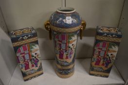 A Chinese famille rose garniture comprising a tall vase with ring handles and a pair of flower