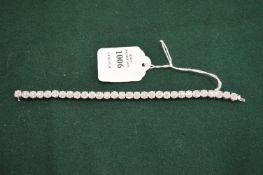 A superb 18ct white gold and illusion set diamond bracelet comprising thirty clusters of diamonds.