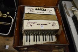 A cased Hohner student accordion.