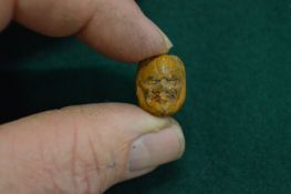 A Japanese bead in the form of a mans head.