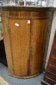 An oak and mahogany hanging bow fronted corner cabinet.