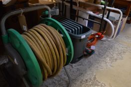A garden hose reel and other items.