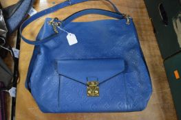 A ladies designer blue leather handbag.