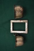 An embossed silver cream jug and sugar bowl and a silver photograph frame.