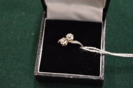 A white metal and diamond crossover ring.