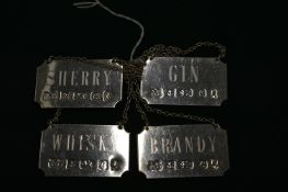 A set of four silver decanter labels.