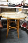 A modern lloyd loom circular glass top bistro table.