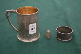 An engraved silver Christening tankard, silver napkin ring and silver thimble.