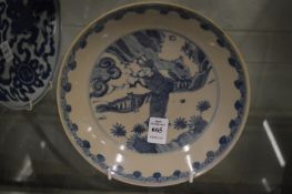 A Chinese blue and white circular dish painted with a figure in a garden setting.