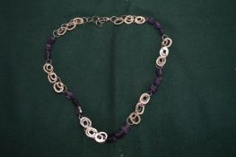 A silver and amethyst necklace.