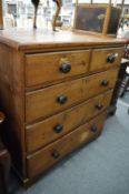 A Victorian varnished pine chest of drawers.
