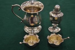 A small silver baluster shaped tankard, pair of silver salts with spoons and a silver pepperette.