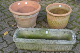 Two terracotta plant pots and a garden trough.