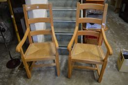 A pair of beech and rush seated armchairs.