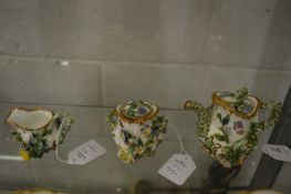 A miniature floral encrusted three piece tea service.