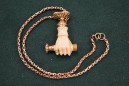 A good fob seal modelled as a hand holding a fob suspended from a curb link yellow metal chain.