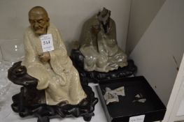 Two Chinese seated figures on hardwood stands (faults).