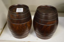 A pair of turned wood barrel shaped boxes and covers.