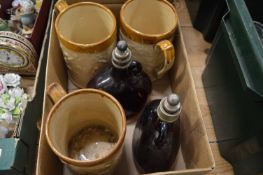 Three stoneware tankards and a pair of amber glazed wine bottles.