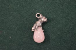 A rose quartz pendant mounted with a bulldog.