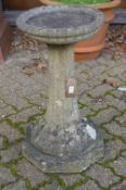 A reconstituted stone bird bath.
