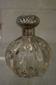 A large cut glass and silver topped scent bottle.