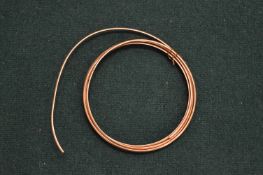 A small coil of yellow metal wire.