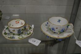 A Meissen floral encrusted cup and saucer together with a similar cup and saucer.