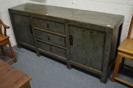 A Chinese sideboard with three central drawers flanked by a pair of cupboard doors with distressed