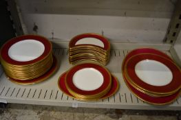 A quantity of Wedgwood dinner plates and side plates with burgundy and gilt borders.