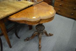 A Victorian figured walnut fold-over card table of shaped outline.