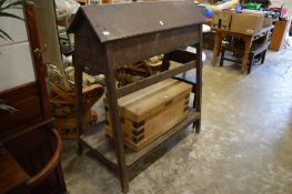 An old stained pine saddle rack of tapering form with a drawer to each end, the legs united by an