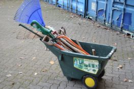 A wheelbarrow containing a quantity of gardening tools.