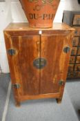 A small Chinese stained pine two door cupboard.