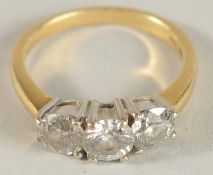 A THREE STONE DIAMOND RING set in yellow gold.