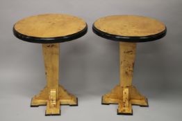 A PAIR OF ART DECO DESIGN MAPLE WOOD CIRCULAR TABLES on column supports. 74cms high x 60cms wide.
