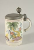A LARGE CONTINENTAL TIN GLAZE TANKARD with pewter lid, the body with a man gardening and various