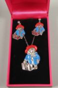 A SILVER AND ENAMEL PADDINGTON BEAR NECKLACE AND EARRINGS.