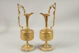 A GOOD PAIR OF CLASSICAL BRONZE EWERS with a band of figures, on a circular marble base, snake