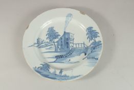 A GOOD 18TH CENTURY TIN GLAZE BLUE AND WHITE CHARGER decorated with a building by a bridge, a